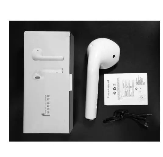 White wireless earbuds with charging case and user manual on a black background