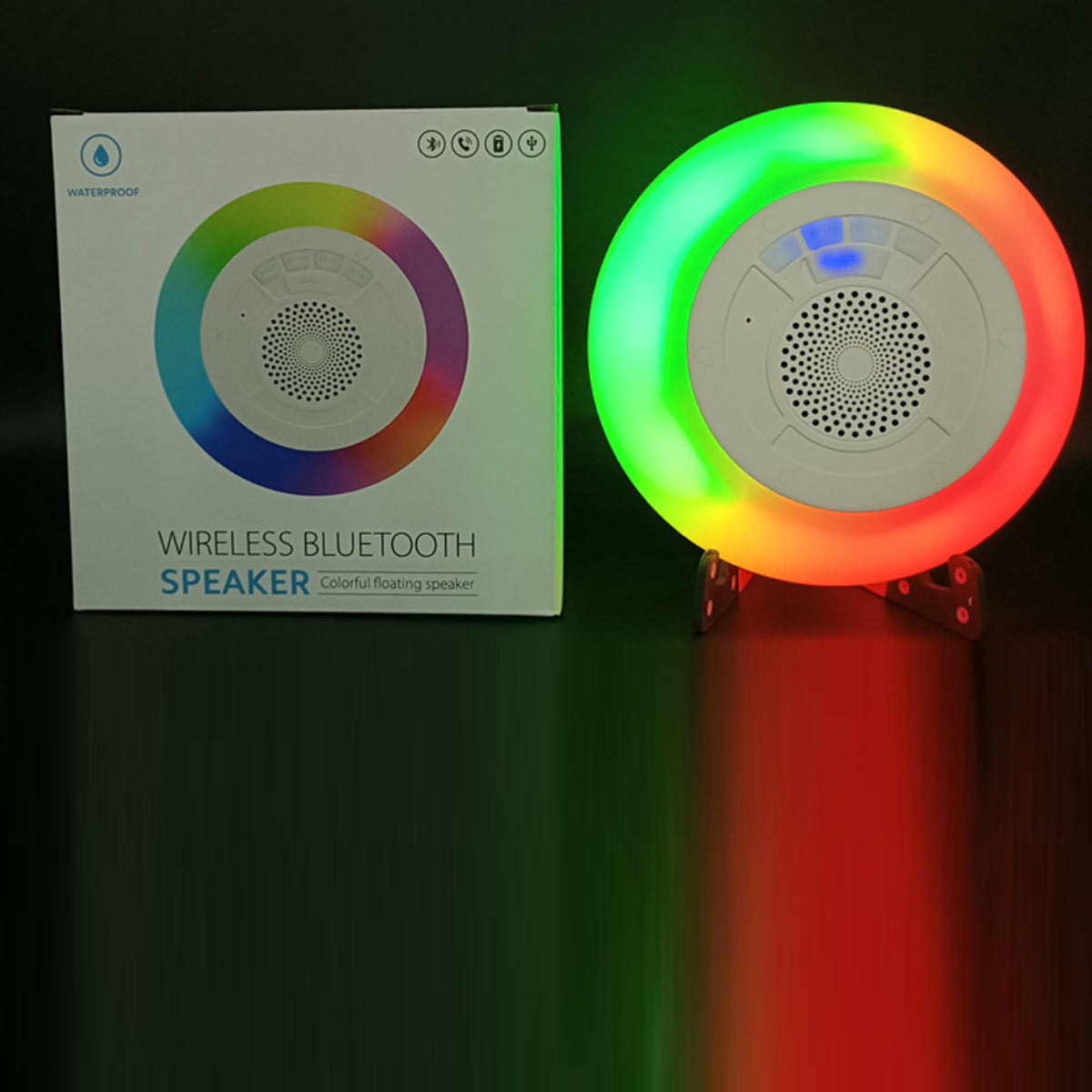Wireless Bluetooth speaker with colorful LED lights next to its packaging on a dark background