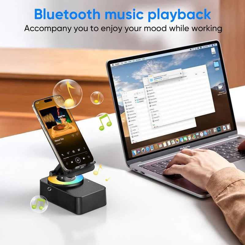 Laptop with Bluetooth music playback device on a desk, with a person using the laptop.