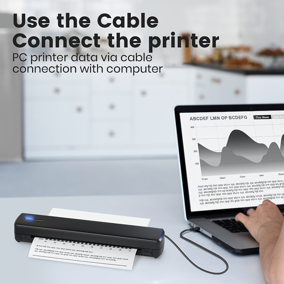Hand holding a cable connecting a portable printer to a laptop on a desk.