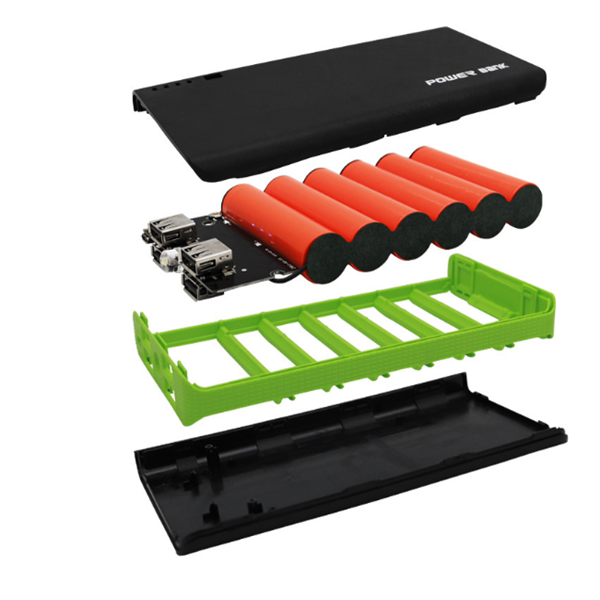 Collection of electronic components including red cylindrical batteries, a black power bank, and green and black trays on a white background.