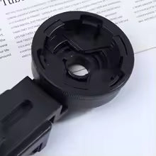 Black plastic component on a white background with text