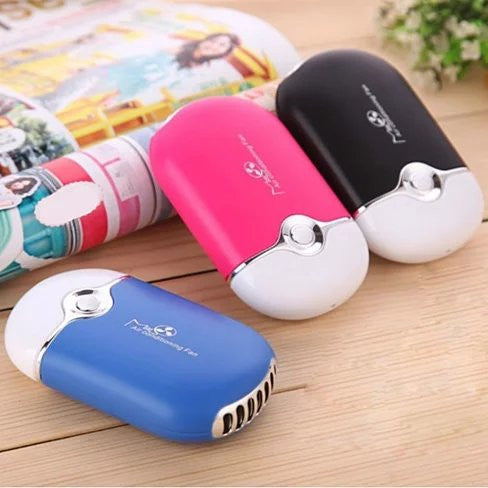 Three handheld electric shavers in different colors on a wooden surface.
